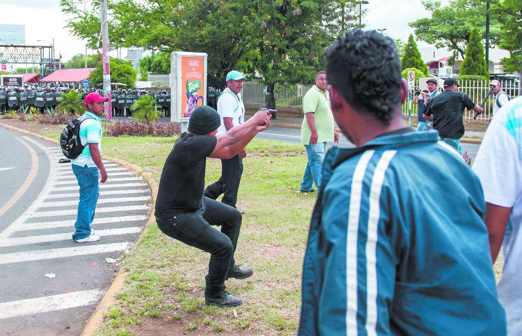 Un paramilitar al servicio de Ortega dispara contra manifestantes desarmados en pleno centro de Managua, en septiembre 2015